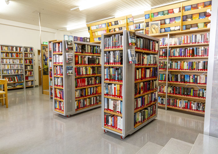 Bibliothek mit vielen Bücherregalen und Büchern in einem modernen Lesesaal